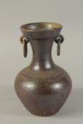 A POTTERY VASE with ring handles. 10ins high.