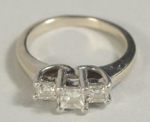 A 14CT GOLD AND PLATINUM THREE STONE DIAMOND RING.