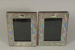 A PAIR OF ART DECO DESIGN SILVER AND BLUE ENAMEL PHOTOGRAPH FRAMES. 7.5 x 6ins.