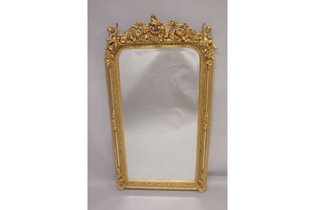A GOOD GILTWOOD MIRROR with cupids and acanthus. 5ft high x 2ft 7ins wide.