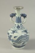 A CHINESE BLUE AND WHITE PORCELAIN TWIN-HANDLE VASE, with dragon and phoenix. 26cms high.