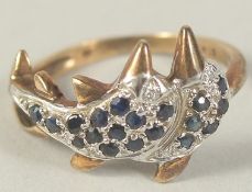 A 9CT GOLD DOLPHIN RING set with black and white diamonds