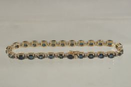 A 14CT GOLD, DIAMOND AND SAPPHIRE LINE BRACELET.