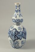 A DUTCH BLUE AND WHITE POTTERY VASE with floral panels. 14ins high.
