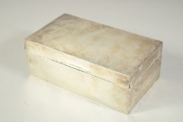 A PLAIN RECTANGULAR SILVER CIGARETTE BOX with cedarwood liner. 7ins long. London 1912