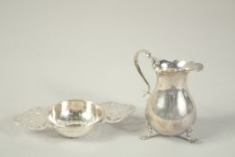 A SILVER MILK JUG, Birmingham 1905 and a TEA STRAINER, Sheffield 1938.