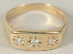 A 9CT GOLD THREE STONE DIAMOND GYPSY RING.