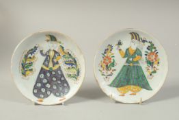 A PAIR OF TURKISH OTTOMAN KUTAHYA PLATES, painted with figures, 14.5cm diameter.