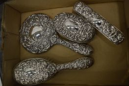 A silver backed four piece dressing table set.