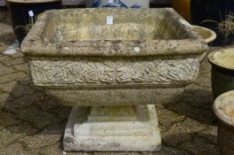A reconstituted stone square shaped pedestal planter.