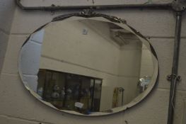 An Art Deco oval mirror.