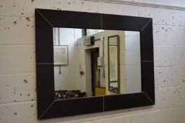 A large rectangular brown leather framed mirror.