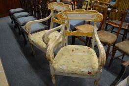 A pair of painted and parcel gilded armchairs.