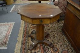 A small oak octagonal shaped revolving 'rent' table.