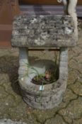 A garden planter modelled as a wishing well.