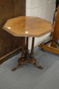 A Victorian octagonal shaped walnut occasional table on turned column supports with carved feet.