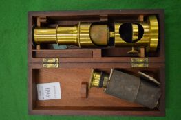 A small mahogany cased brass microscope.