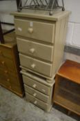 A pair of grey painted pine three drawer chests.
