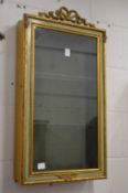 A decoratively painted and gilded hanging display cabinet.