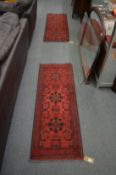 Two small Persian style red ground runners 146cm x 52cm and 153cm x 53cm.