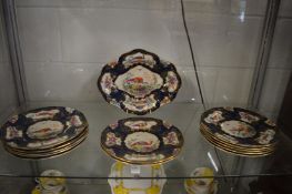 A Booths part dessert service decorated with a blue scale ground and panels of exotic birds.