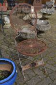 A wrought iron folding garden chair.