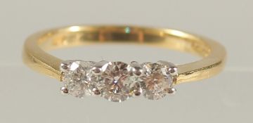 AN 18CT YELLOW AND WHITE GOLD THREE-STONE RBC DIAMOND RING. Diamonds 0.50ct.