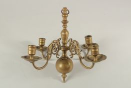 A FOUR BRANCH BRASS CANDELABRA. 11ins high.