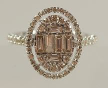 A LARGE OVAL CLUSTER RING SET with baguette cut and round brilliant cut diamonds with diamond