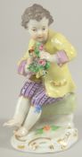 A MEISSEN PORCELAIN FIGURE OF A BOY in a yellow coat and carrying a garland of flowers. 4.5ins high.