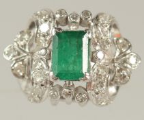 A GOOD 18CT WHITE GOLD EMERALD AND DIAMOND CLUSTER RING.