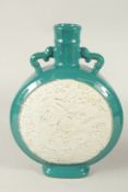 A CHINESE TURQUOISE GLAZE CARVED DRAGON AND PHOENIX MOON FLASK, the base with character mark. 34.