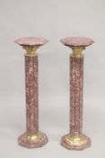 A PAIR OF VEINED RED MARBLE CLUSTER COLUMNS with octagonal tops and bases. 3ft 4ins high.