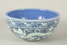 A CHINESE BLUE GROUND PORCELAIN BOWL, with incised white dragons. 26.5cms diameter.