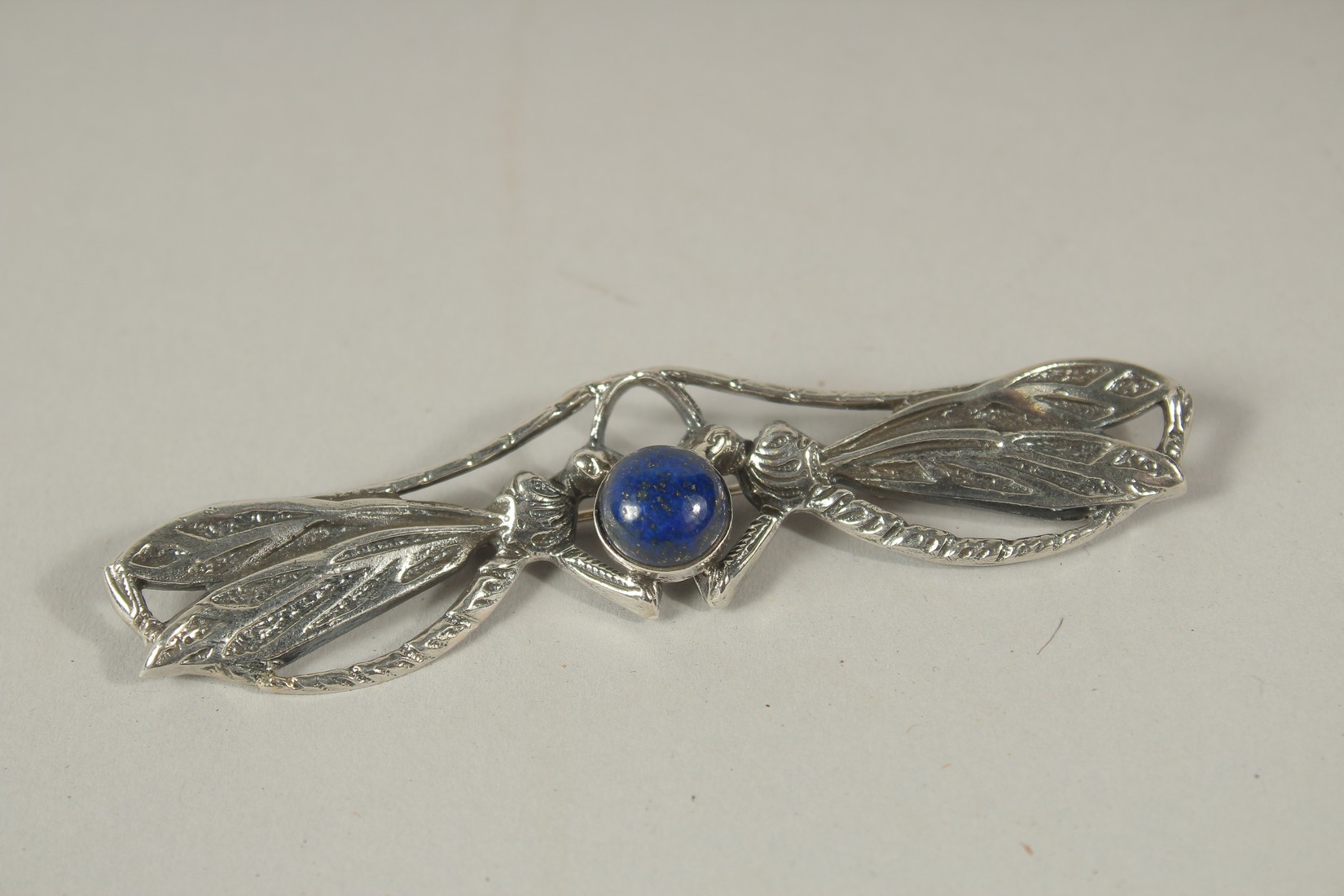A SILVER AND LAPIS DRAGONFLY BROOCH.