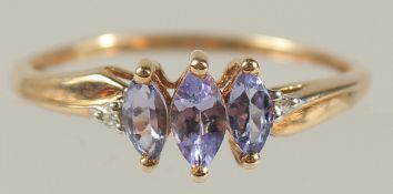 A 9CT YELLOW GOLD RING SET WITH THREE MARQUISE TANZANITES AND SMALL R/C DIAMONDS. Tanzanites 0.18ct.