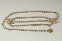 A LONG CHANEL GILT BELT with pendant and tie, double C emblem. 110cms long.