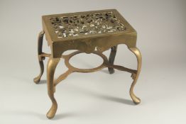 A LARGE BRASS TRIVET with pierced top and four curving legs. 1ft wide x 4ft high.