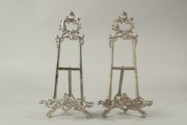 A PAIR OF SILVER PLATED PICTURE EASELS. 40cms long.