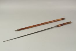 AN EARLY WOODEN CASED SWORD STICK with engraved blade. 3ft long.