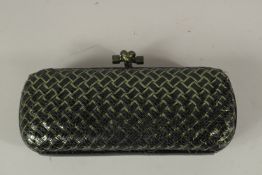 A BOTTEGA VENETA, ITALY, CLUTCH BAG, black cross hatch decoration, with dust cover. 24cms long.
