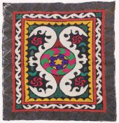 AN UZBEK SUZANI EMBROIDERED TEXTILE, with central foliate motif in purple, yellow, green, red,