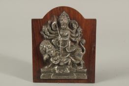 A FINE SOUTH INDIAN SILVER HINDU DEITY MOUNTED TO A WOODEN PLAQUE, 16cm high.