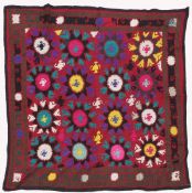AN UZBEK SUZANI EMBROIDERED TEXTILE, with polychrome decorative roundels, 136cm x 124cm.