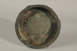 A 13TH CENTURY PERSIAN SELJUK BRONZE DISH, the centre depicting a mythical creature, 15cm diameter.