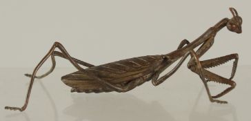 A BRONZE OKIMONO OF A PRAYING MANTIS, 10cm long.