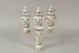 A FINE GARNITURE OF THREE CHINESE FAMILLE ROSE PORCELAIN JARS AND COVERS & TRUMPET VASE, each