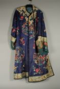 A CHINESE EMBROIDERED BLUE SILK ROBE, adorned with threaded floral sprays and panels of figures.