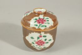 A CHINESE CAFE-AU-LAIT FAMILLE ROSE PORCELAIN CIRCULAR POT AND COVER, with enamel-painted floral