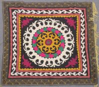 AN UZBEK SUZANI EMBROIDERED TEXTILE, with central foliate motif in yellow, green, maroon, black, and